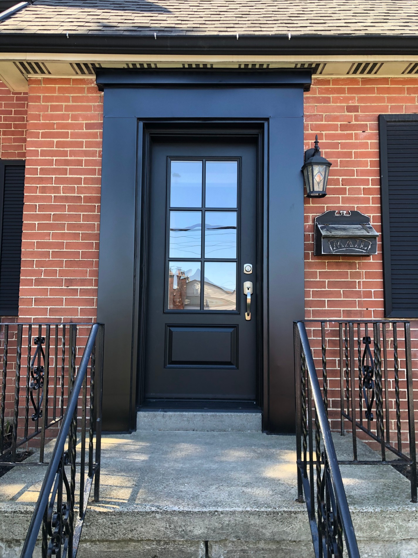 Black front door on a brick home with steps and lantern Black front door on a brick home with steps and lantern