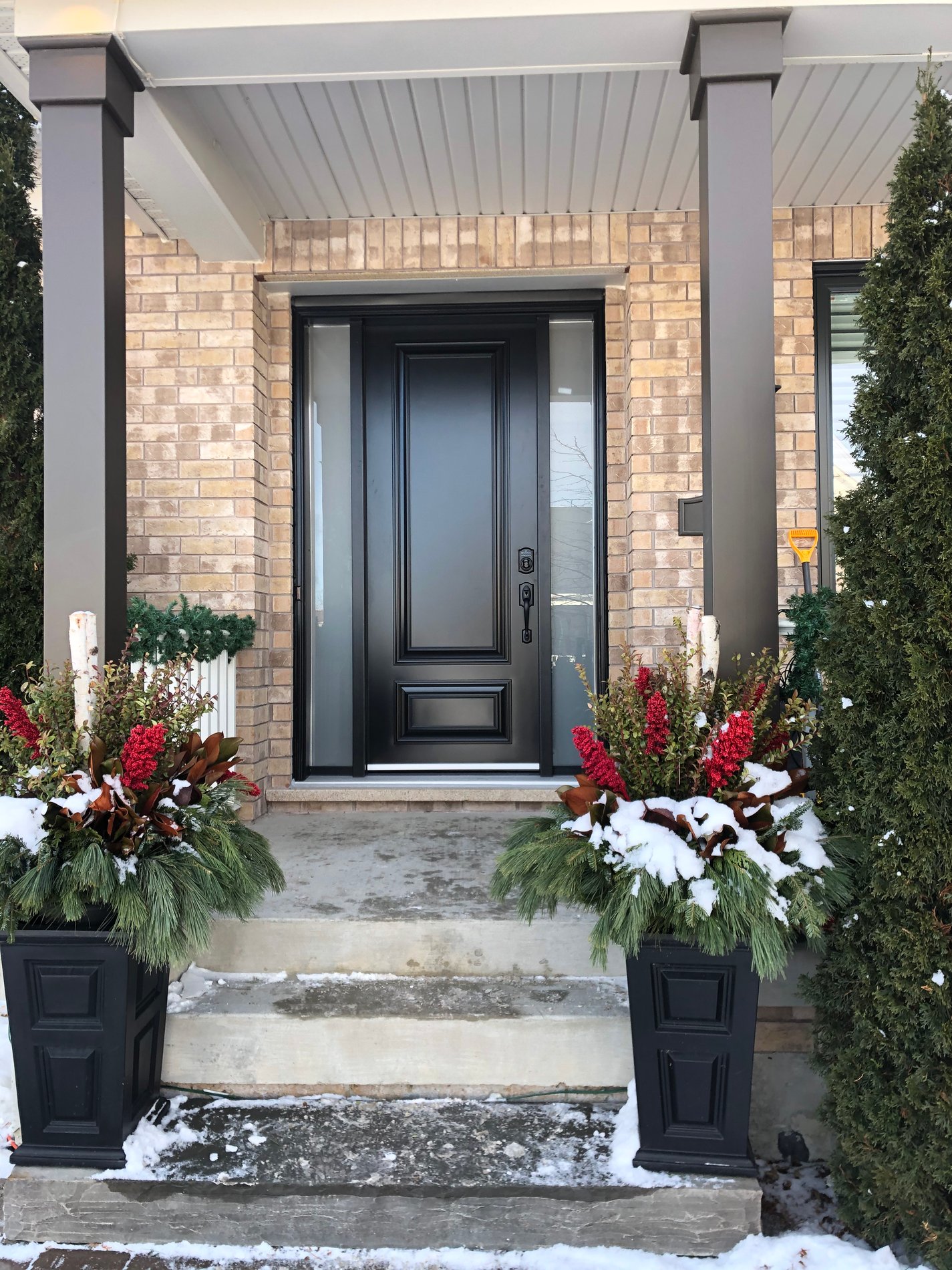 Front entrance with winter planters and a new entry door