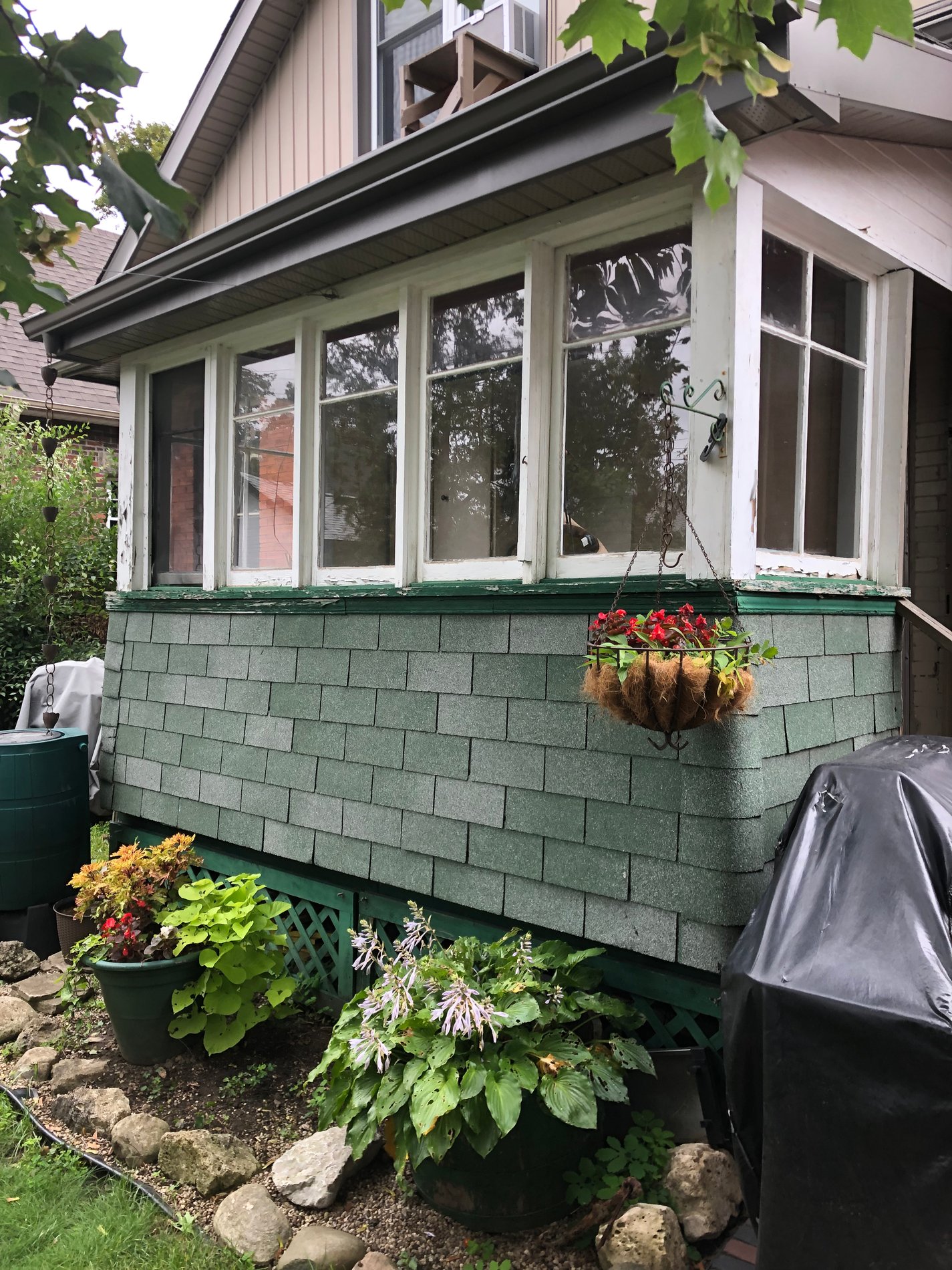 Green-sided sunroom with plants and window boxes