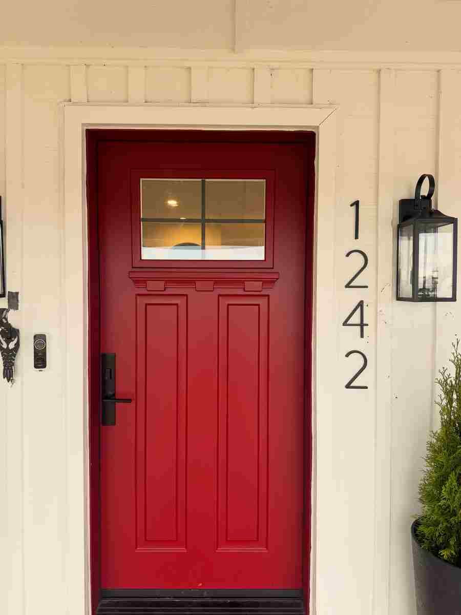 Red Craftsman-style entry door with board-and-batten panels Red Craftsman-style entry door with board-and-batten panels