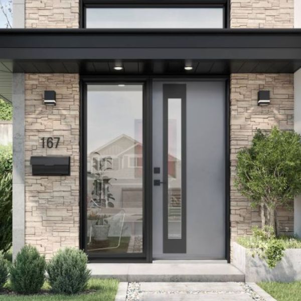 Modern gray entry door with sidelight and transom window on a stone-clad home entrance