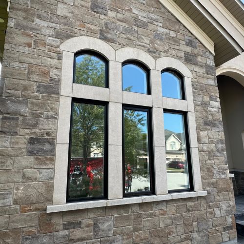 Stone wall with modern black-framed windows