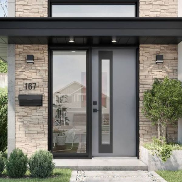 Modern gray entry door with sidelight and transom window on a stone-clad home entrance